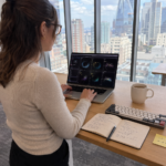 Woman working at kitchen table with AI chat interface on laptop